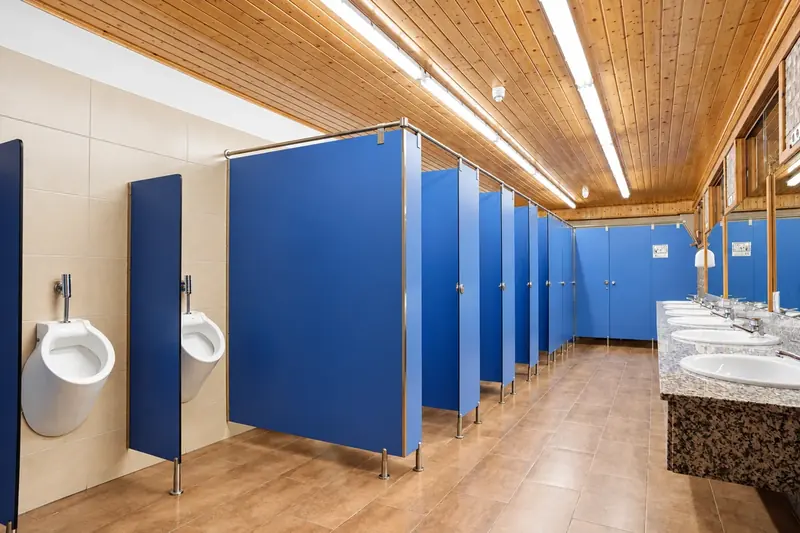 Interior del edificio de sanitarios de La Mola con duchas de agua caliente y acabados de madera